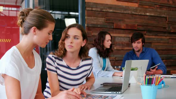 Group of graphic designer interacting while using laptop