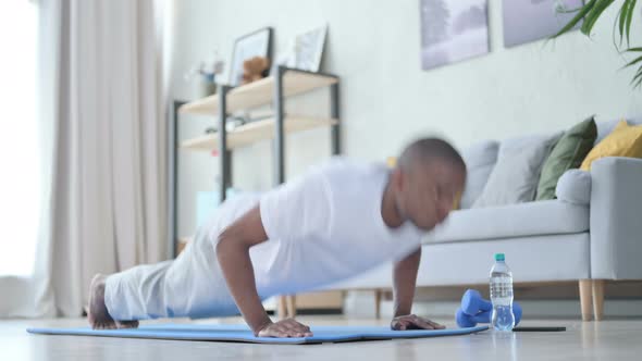 Young African Man Doing Pushups on Yoga Mat at Home
