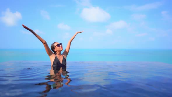 Young asian woman enjoy around outdoor swimming pool for leisure