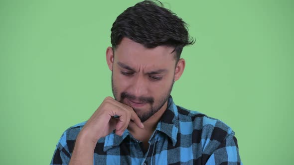 Face of Stressed Young Bearded Persian Hipster Man Thinking