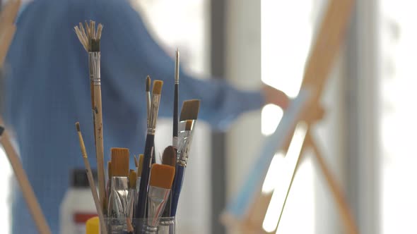Artist painting in art studio Brushes in focus
