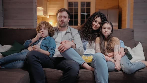 Family Watching a Movie Together at Home Hugging and Laughing with Comedy