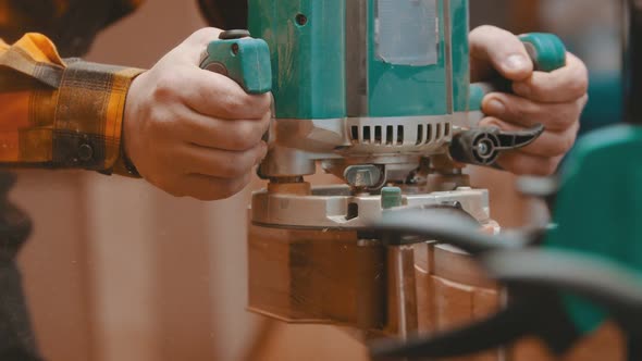 Carpentry Indoors - a Woodworker Polishes and Cutting Off the Side of a Wooden Detail