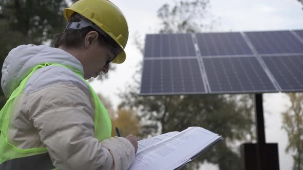 Worker inspects the solar panels and reports the information to the management