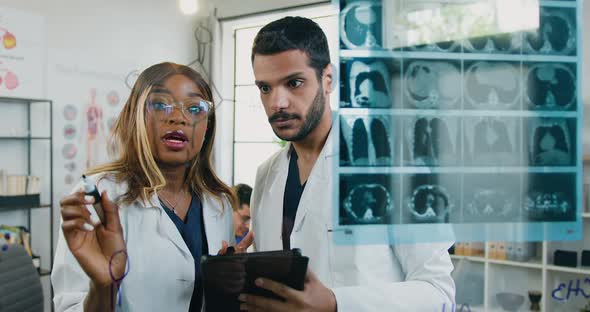Mixed Race Male and Female Medical Workers Standing Near Glass Wall in Medical Office