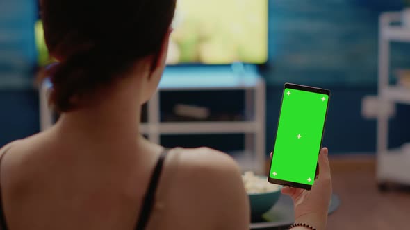Young Person with Vertical Green Screen Display on Smartphone