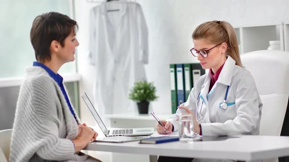 Mature Woman Patient Visiting Doctor at Modern Clinic Having Consultation Medium Shot