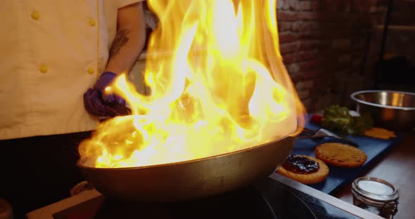 Super Slow Motion, Big Fire with Hamburger Steaks From Wok Pan. Close Up