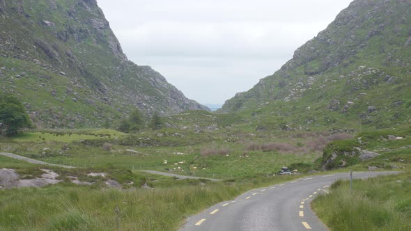 Car Traveling At The Winding Road Of The Gap Of Dunloe In Killarney National Park In Ireland. aerial