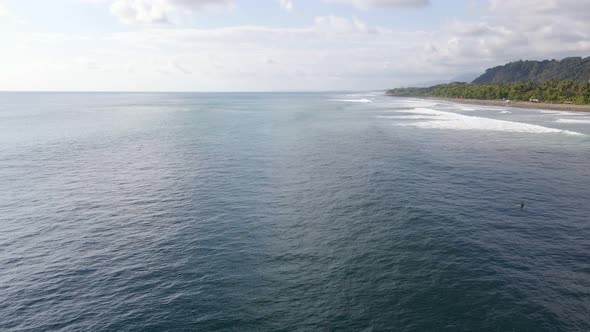 Aerial view of small waves in the ocean in Dominical Beach in Costa Rica, Static Wide shot