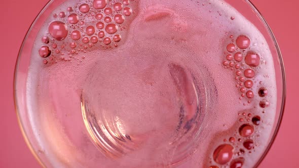 Closeup of Glass with Sparkling Rose Wine Decorated Gold Star Confetti Celebration Party