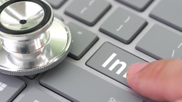 INFO Key Being Pressed on a Computer Keyboard Near Stethoscope