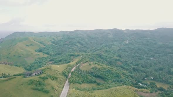 Cinematic aerial drone view of a picturesque landscape of ocean meeting mountains in Batanes, Philip