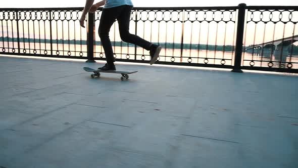 Man on a Skateboard Performs a Trick Leap on a Board at Sunset, Slow Motion