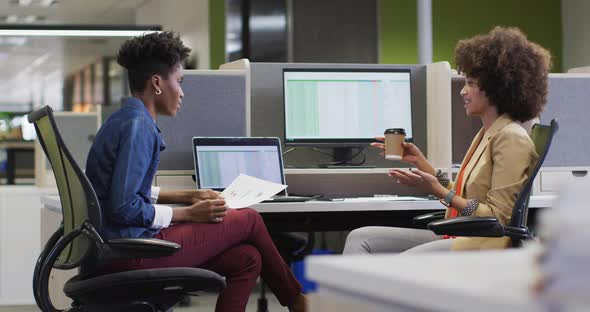 Video of diverse businesswomen working on project and using laptop