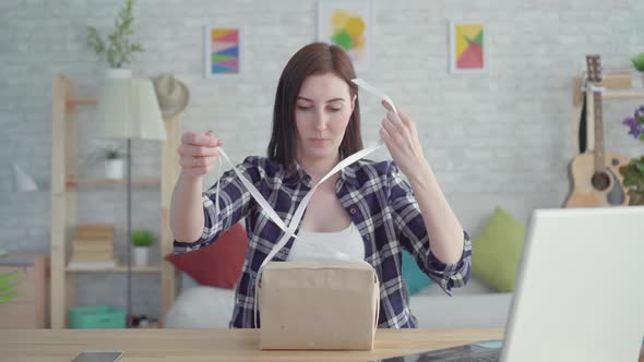 Portrait Young Woman Wraps a Gift Sitting at the Table