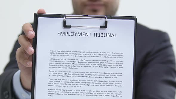 Entrepreneur Showing Employment Tribunal Document at Camera