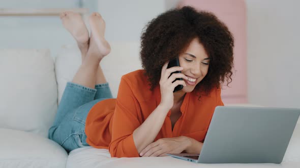 Smiling African American Girl with Curly Hair Lying at Home Resting Talking on the Phone Looking at