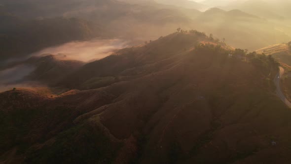 Aerial view of sunrise with fog above mountains