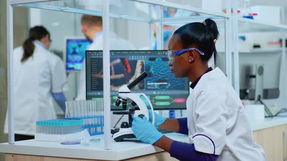 Black Biochemist Woman Sitting in Lab Analysing Blood Tests