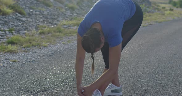 Female Athlete Doing Stretching Exercises in Nature