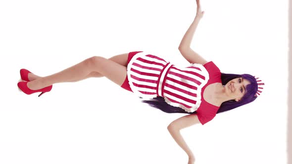 Caucasian Model in a Striped Apron Inviting with Her Gesture and Softly Bending Her Knees Vertical