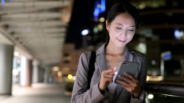 Woman use of smart phone in city at night 