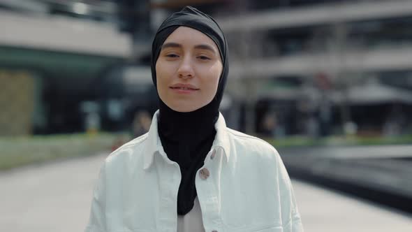 Smiling Arabian Woman Looking to the Camera Standing Outdoors with Background of Shopping Center