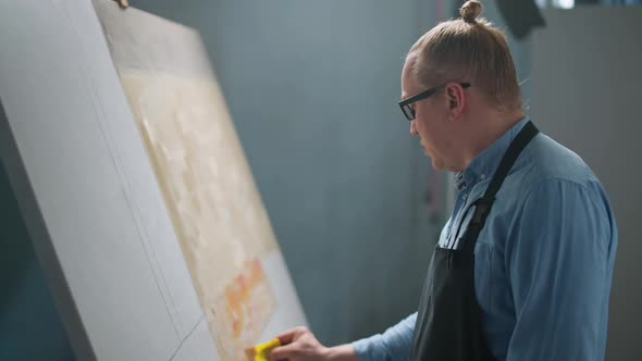 Artist's Workshop Creative Person at Work a Talented Adult Man Artist Covers the Canvas with Beige