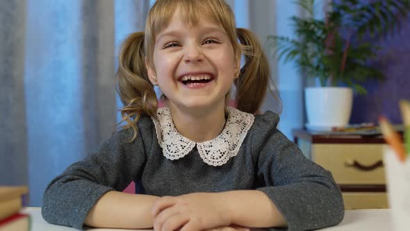 Child Girl Pupil Studying Homework During Online Lessons at Home Kid Laughing Looking at Camera