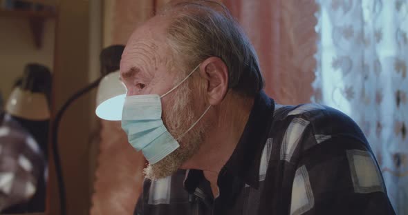 Portrait of Lonely Senior Man Wore in Medical Mask Looks at Camera