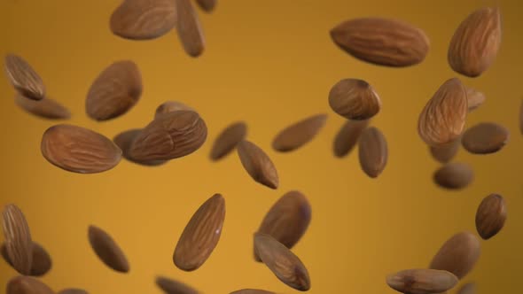 Closeup of Delicious Almonds Bouncing Up on the Yellow Background