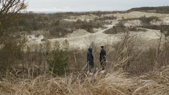 Two Friends Are Standing On Hill In Nature. Around The Tree And Dry Grass.