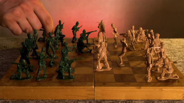 Closeup Playing a Chess Game on a Wooden Chessboard with Plastic Toy Soldiers