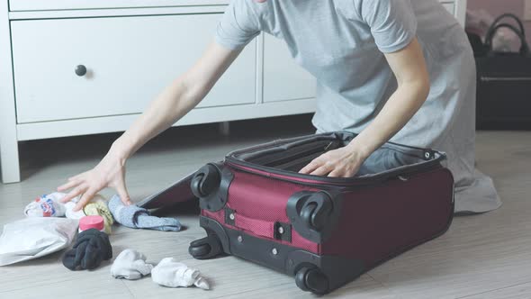 Unrecognizable Female Hands Packing Red Suitcase Putting Socks Into Floor Room