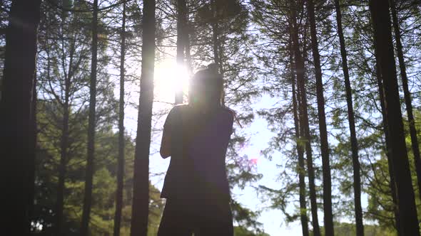 A Woman in Black Clothes Goes in for Sports in the Forest. Jumps, Strikes