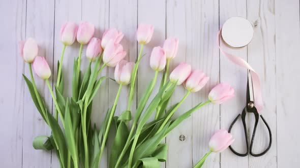 Step by step. Florist wrapping pink tulips in bouquet