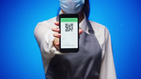 Woman Worker Showing on Phone Vaccination Passport with Qr Code on Blue Background International