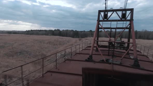 FPV Drone Flies Smoothly Near Rusty Abandoned Walking Excavator