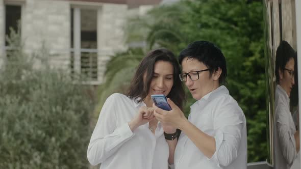 Middle Age Pretty Female Friends Taking Selfies Outside on Street in Summer