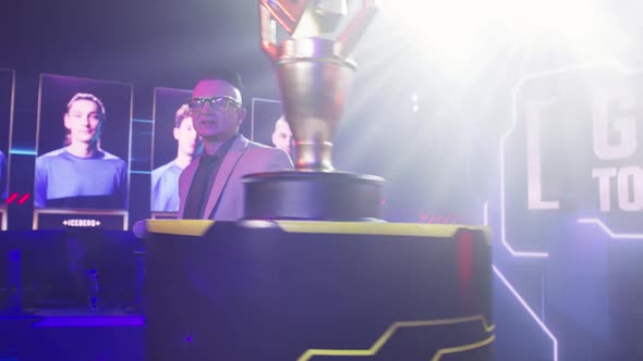 Male Announcer Showing Gaming Tournament Trophy