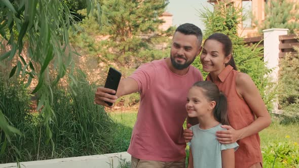 Happy Family Taking Selfie In Backyard