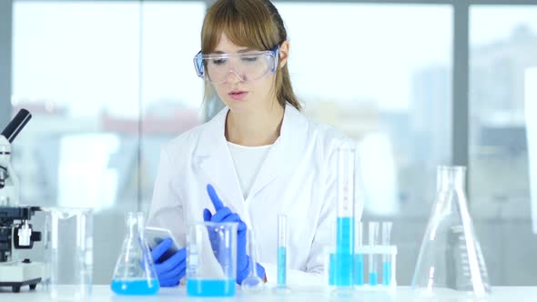 Female Scientist Using Smartphone in Laboratory