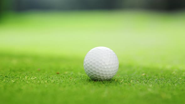 Man in a golf glove pushing a ball