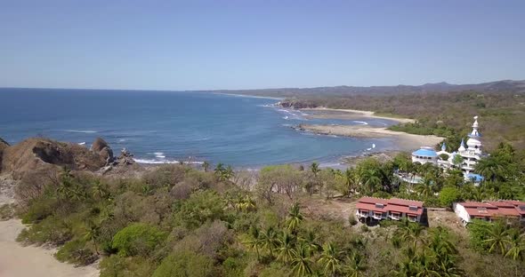 Aerial drone view of the beach, rocks and tide pools in Guiones, Nosara, Costa Rica.