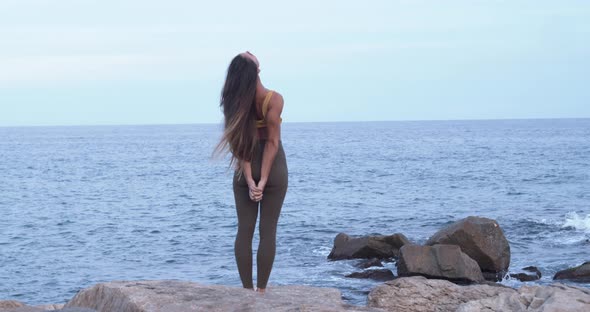 Slow Motion of a Woman Practicing Yoga in Front of the Sea