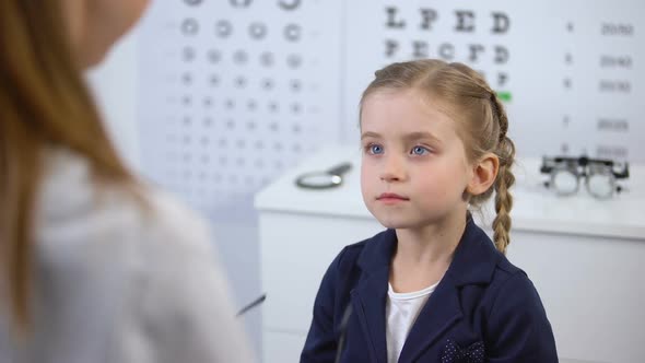 Optician Putting Glasses on Schoolgirl, Little Client Happy With Stylish Eyewear