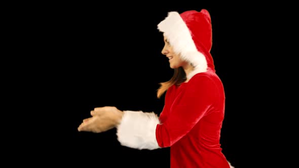 Pretty brunette in santa hat blowing over hands