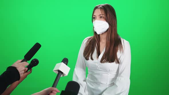 Caucasian Female in a Medical Mask Gives an Interview to Journalists Communication with the Press