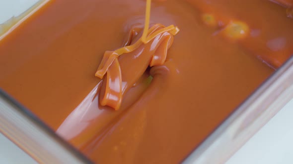 Tasty Light Brown Caramel Sauce Falls Slowly in Mold